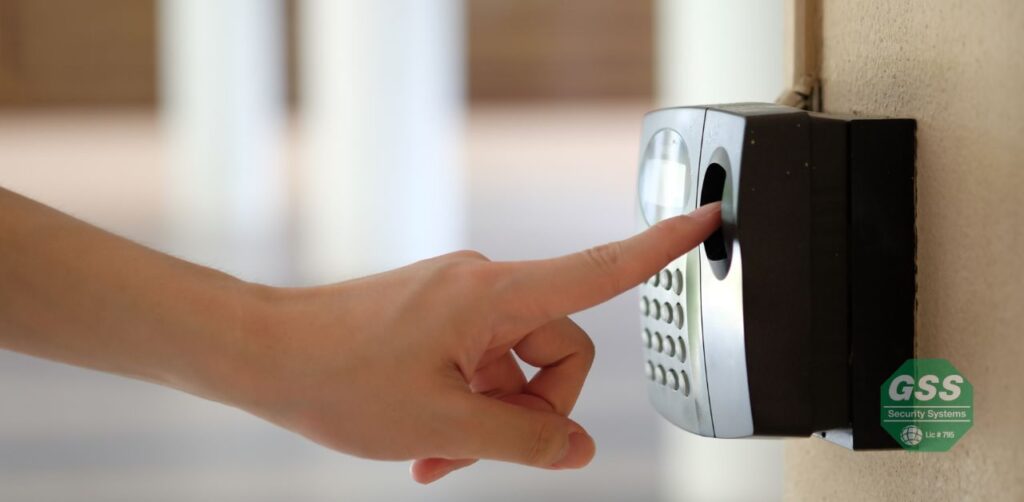 A person using a fingerprint scanner to access a secured gate.