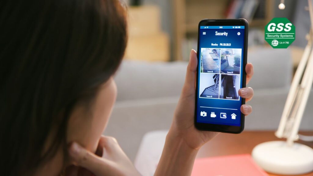 A modern home interior with a sleek smartphone displaying a home security app interface.